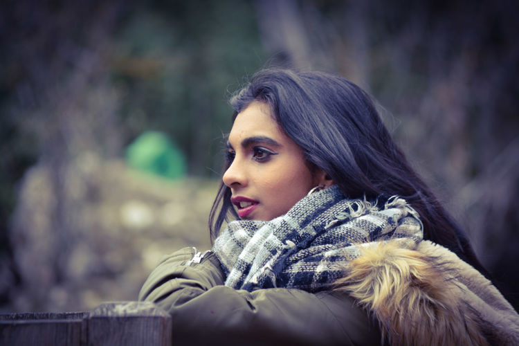 Side view of woman wearing warm clothing looking away in park