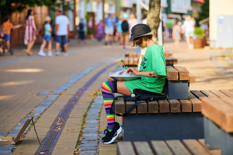 Boy sitting on street in city