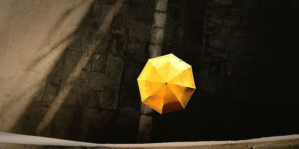 Close-up of yellow umbrella on wall