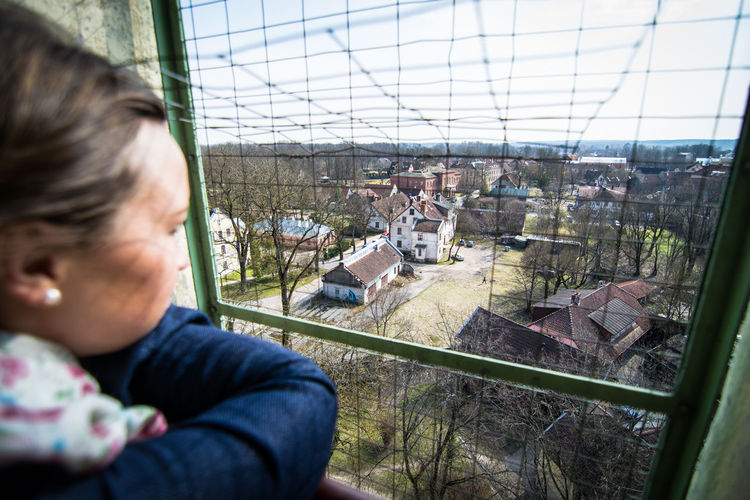 Portrait of woman looking through window
