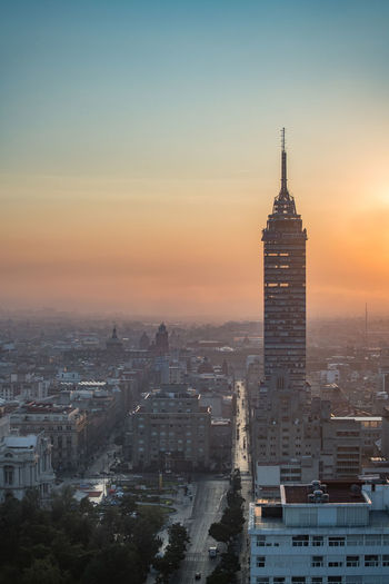 Torre latinoamericana amidst cityscape against sky during sunrise