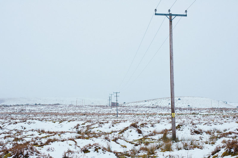 Snow covered field against clear sky