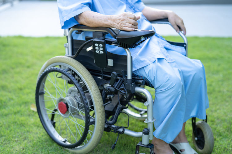 Midsection of man sitting on wheelchair