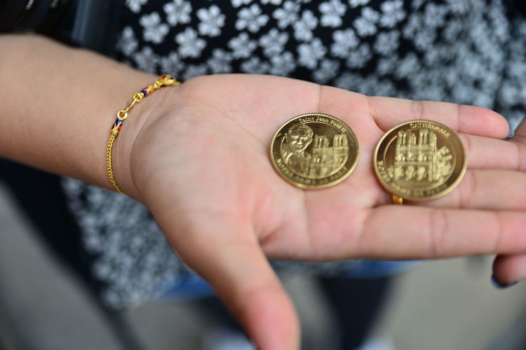 Midsection of woman holding gold coins