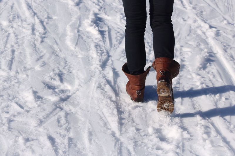 Low section of person walking on snow