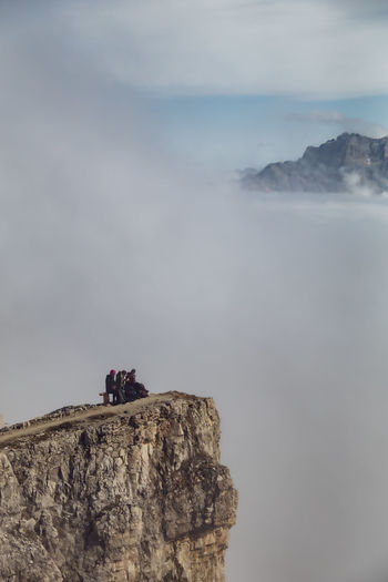 View of cliff on mountain against cloudy sky