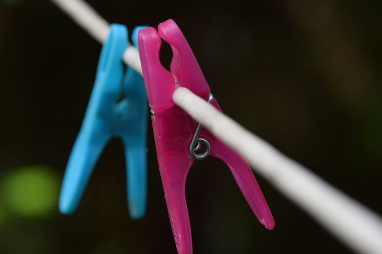 Close-up of multi colored clothespins hanging on clothesline