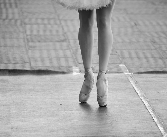 Low section of ballerina dancing on floor
