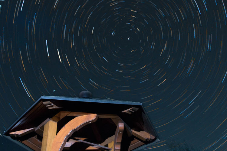 Low angle view of gazebo against star field