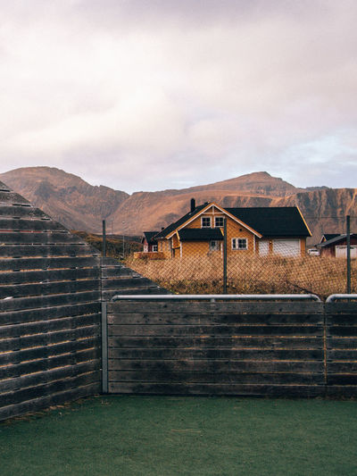 Houses on mountain against cloudy sky
