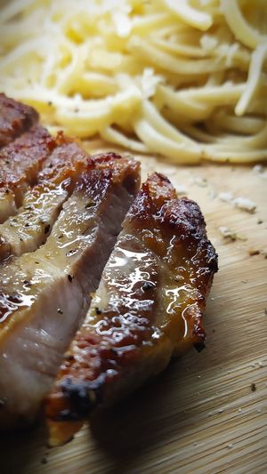 High angle view of sliced stake with pasta in plate on table