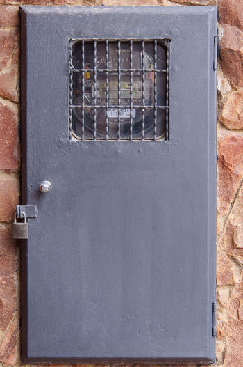 Close-up of locked electric meter on wall