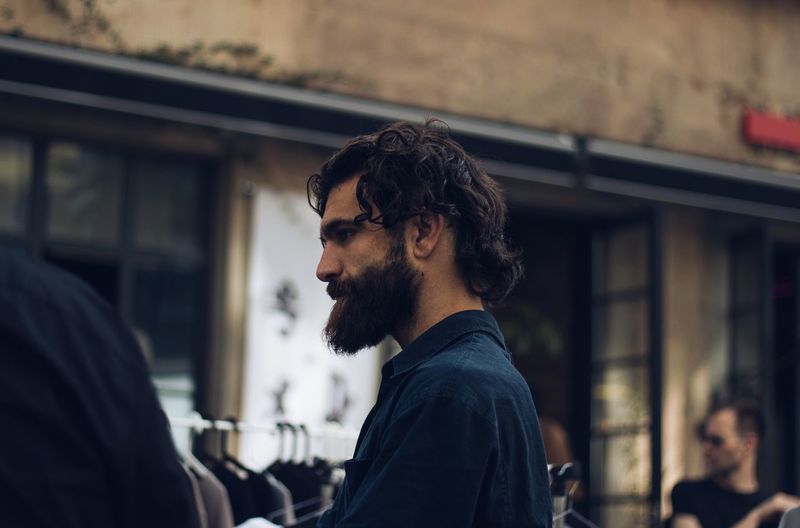 Side view of bearded man standing at market