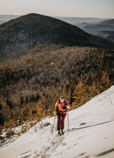 A woman backcountry skis up baldface mountain, new hampshire.