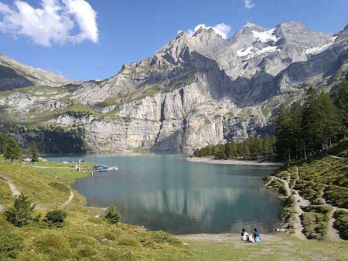 Scenic view of oeschinen lake by mountains against sky