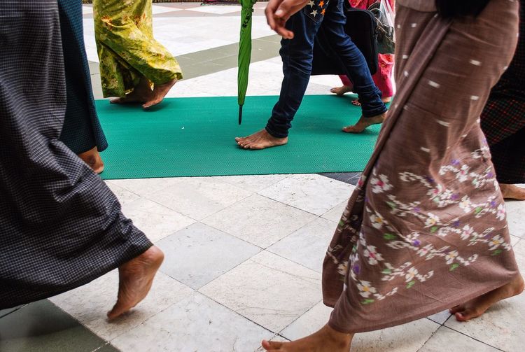 Low section of people walking barefoot in temple
