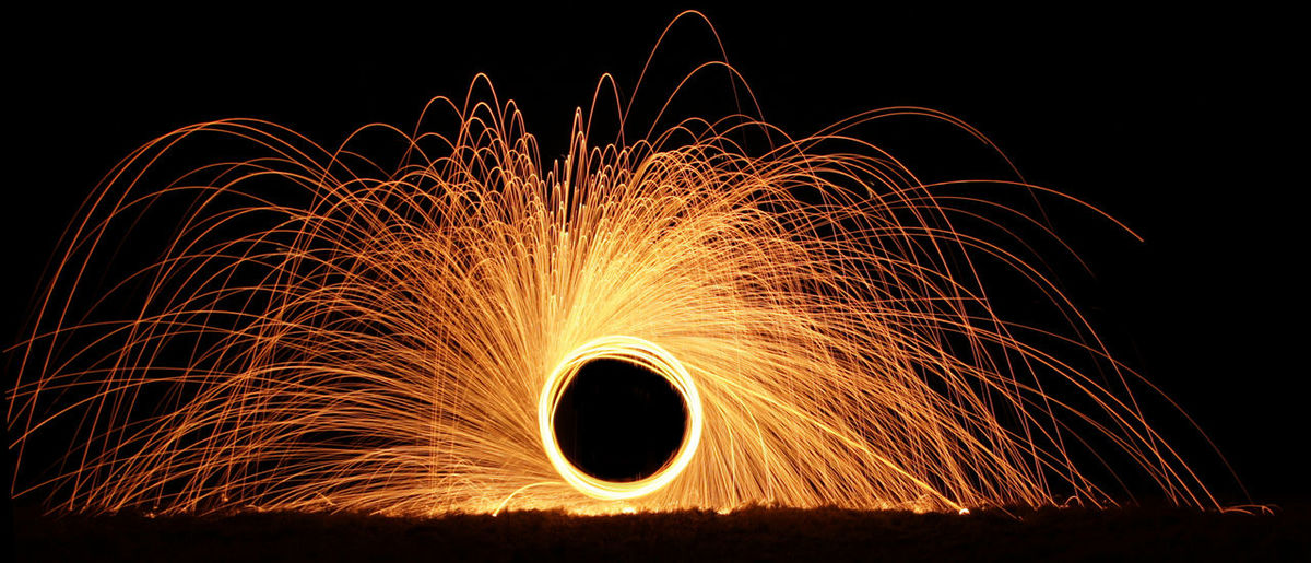 Wire wool spinning against black background - stock photo