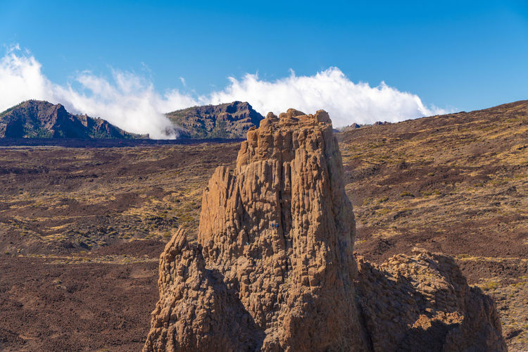 El teide national park with red rock formation, people climping