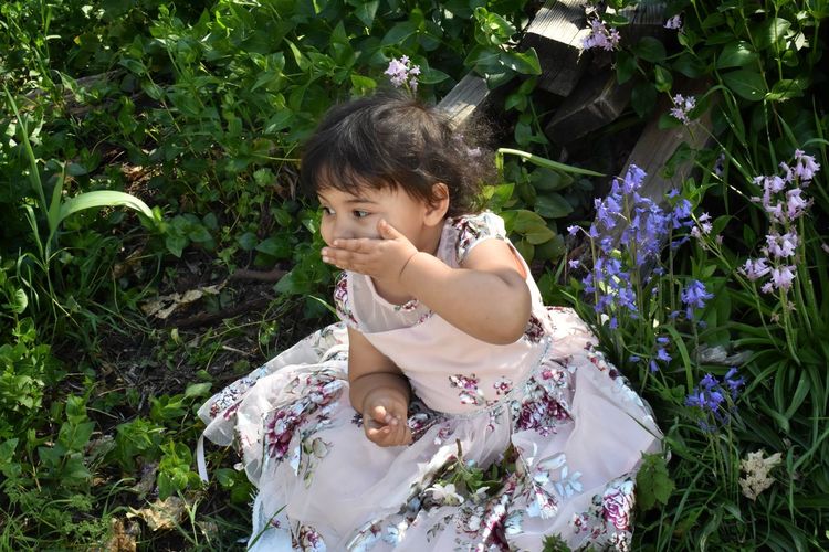 Baby girl giggling in flower garden