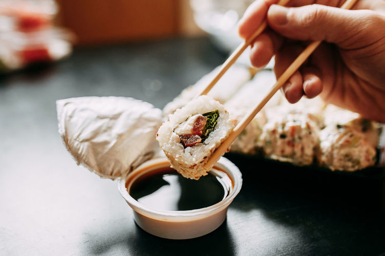 Midsection of person holding sushi