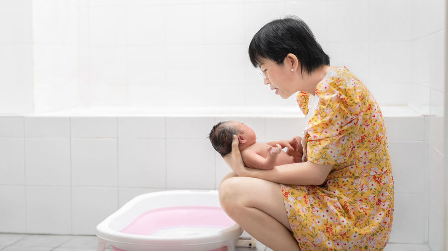 Side view of mother and daughter in bathroom