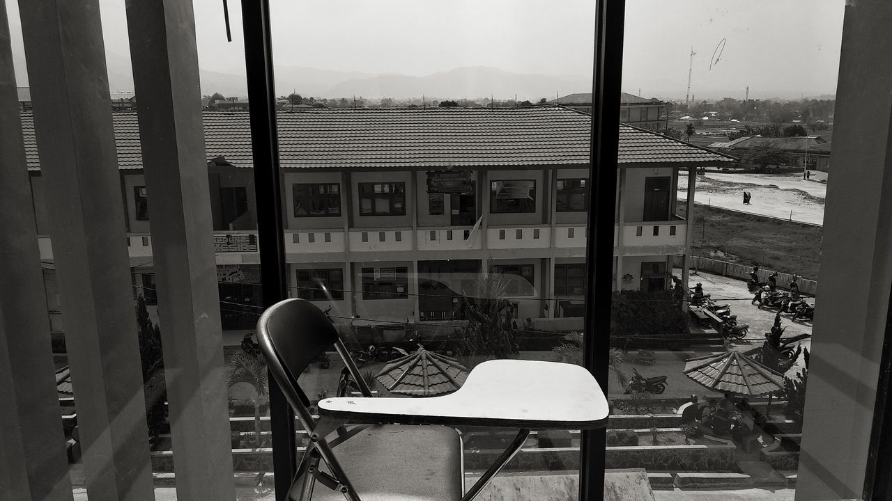 EMPTY CHAIRS AND TABLES AGAINST BUILDING