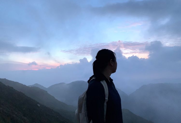 Woman standing against mountains and sky