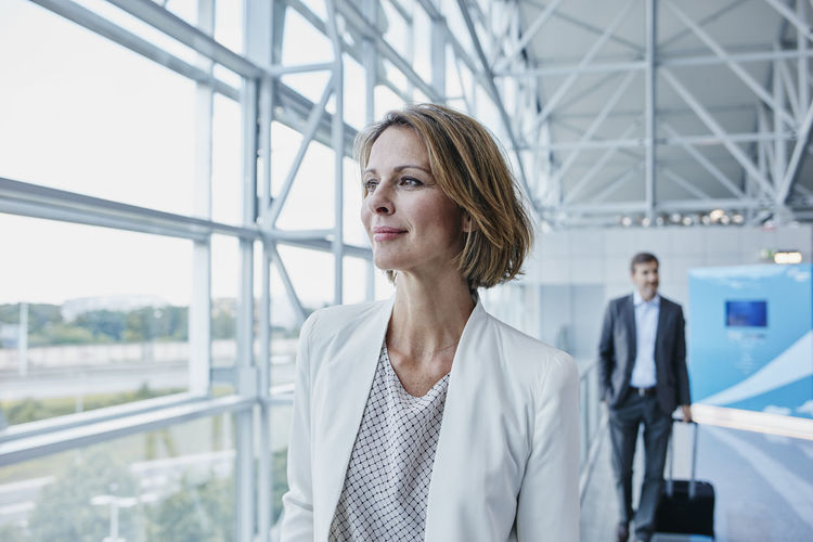 Confident businesswoman at the airport looking out of window