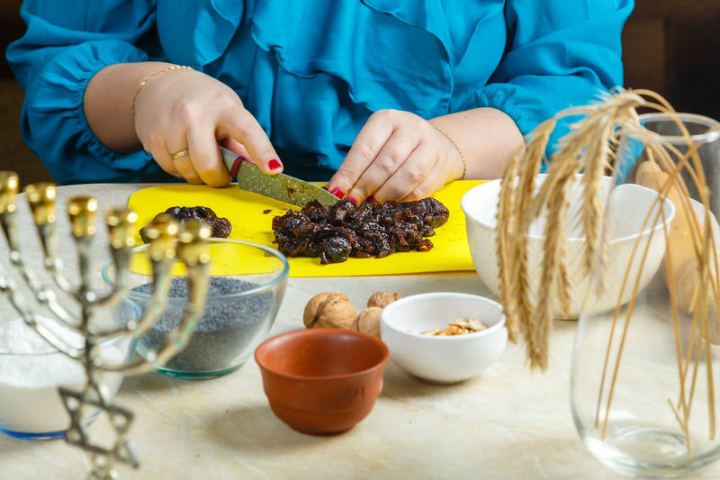 Hands make prunes filling for poppy-seed gomentashi cookies traditional for the jewish holiday purim