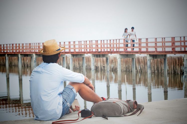 Rear view of person sitting against sky