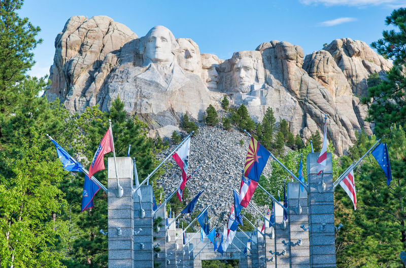 Low angle view of flags on rock against sky
