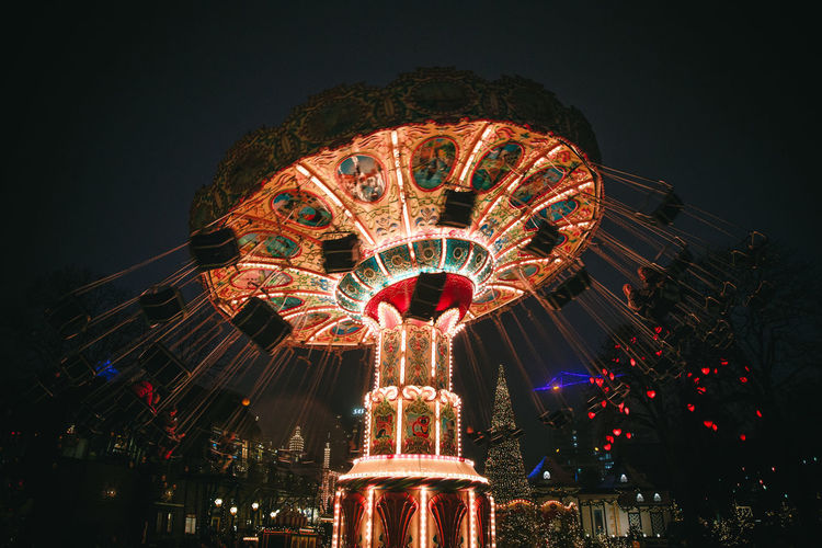Illuminated chain swing ride spinning at night
