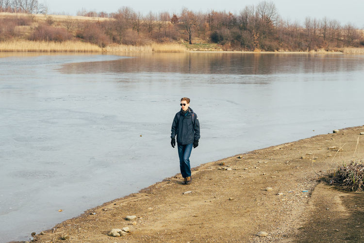 Full length of man standing walking by river