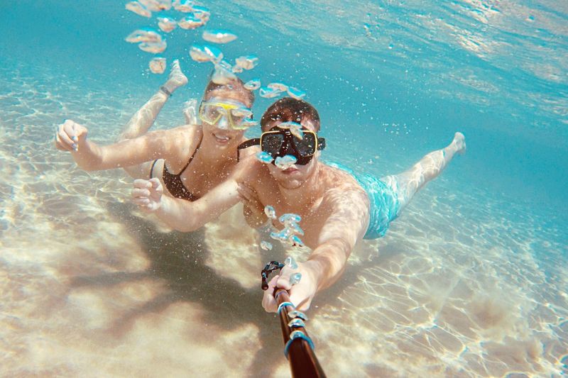 Full length of couple taking selfie underwater