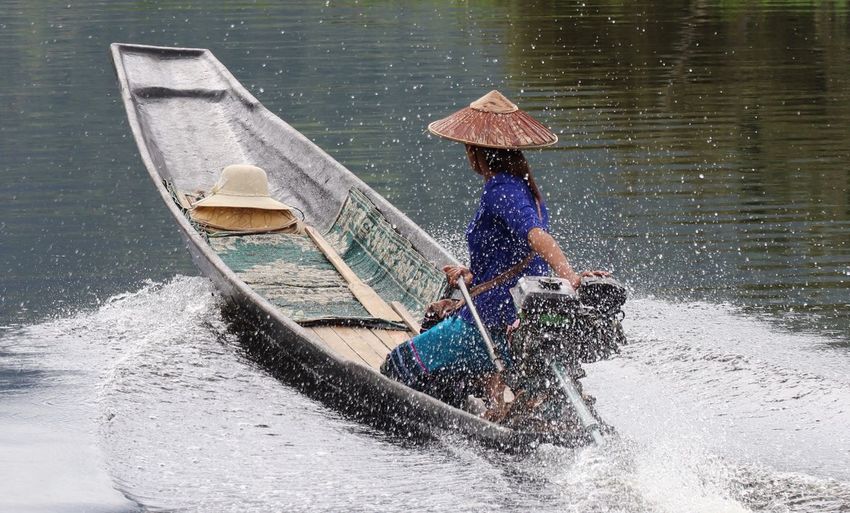 Side view of woman on boat in sea