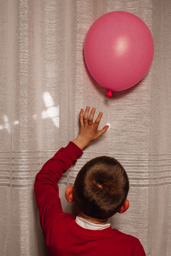 Rear view of boy with balloons