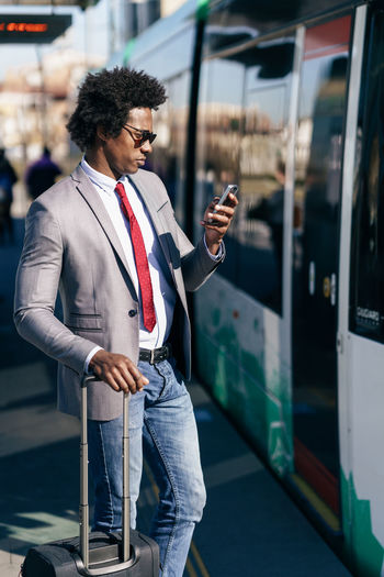 Young man using mobile phone on train