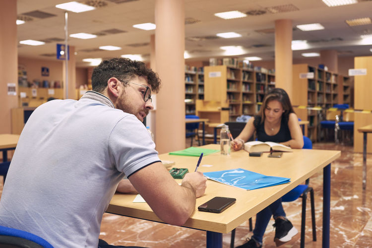 A young couple is studying in the university library