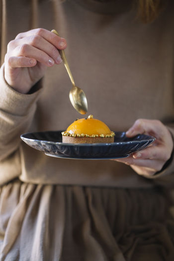 Woman eating peach tartlet with fork