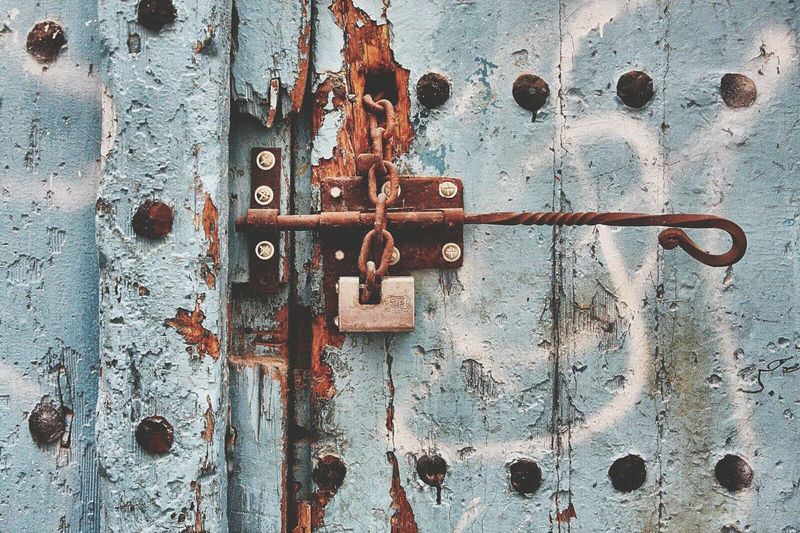 Close-up of rusty latch on old wooden door
