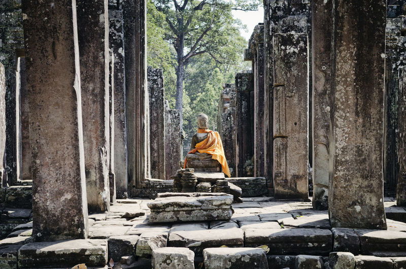 Statue of buddha sitting at temple