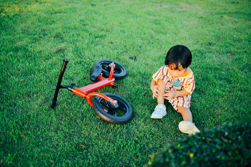 High angle view of boy playing with push scooter on field