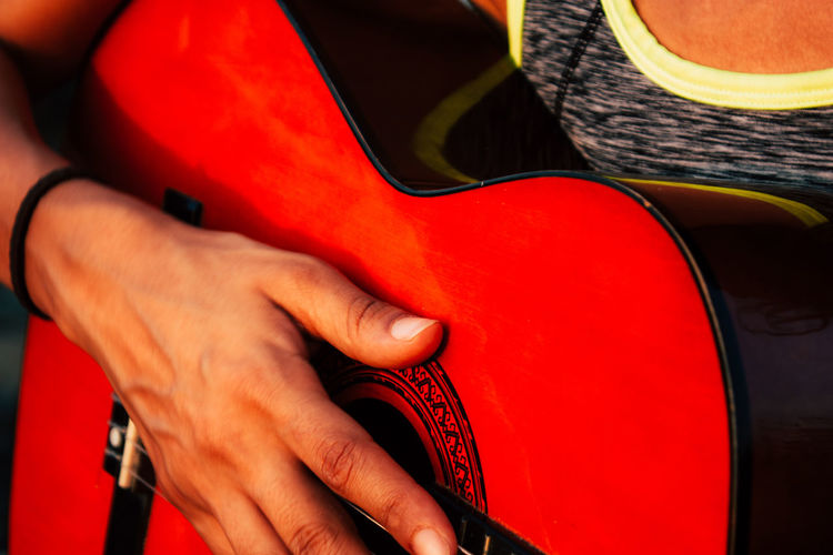 Midsection of man holding guitar