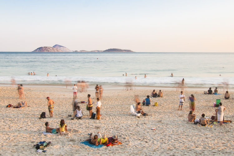 Panoramic view of people on beach against clear sky