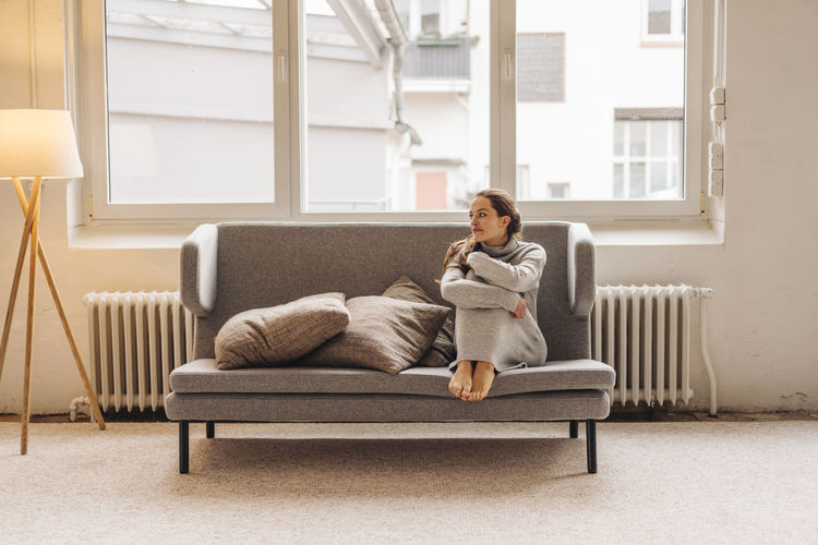 Woman sitting on couch looking sideways
