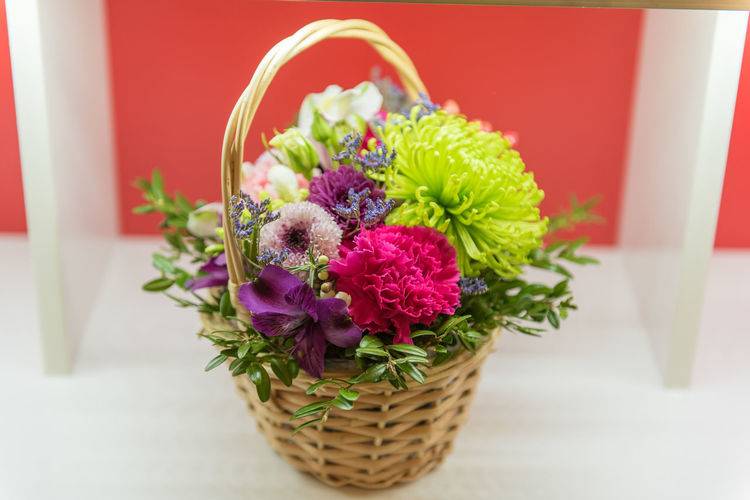 Close-up of multi colored flowers in basket on table
