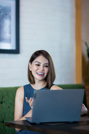 Portrait of a smiling young woman using phone