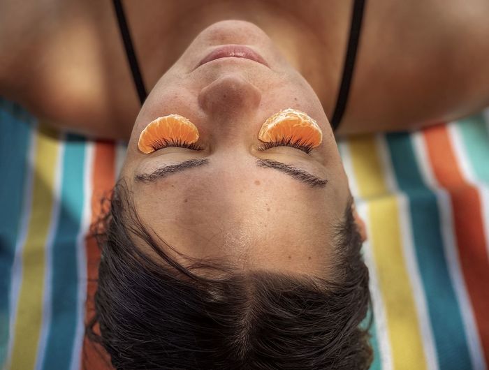 Close-up portrait of woman relaxing at beach 