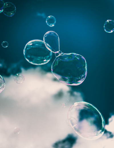 Close-up of bubbles against cloudy sky 
