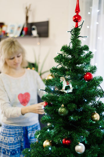 Portrait of girl decorating christmas tree at home